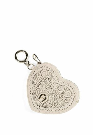 Hartvormige beige leren sleutelhanger met ingewikkeld bloemmotief en metalen ring en clipbevestigingen.