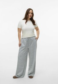 Camiseta blanca de manga corta combinada con pantalones anchos de rayas grises y blancas. Los pantalones cuentan con una cintura con cordón y una textura de tela suave.