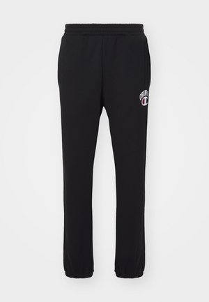 Pantalons de jogging en coton noir avec une taille élastique et des poignets. Présente un petit logo brodé "Champion" en blanc et rouge sur la cuisse gauche.