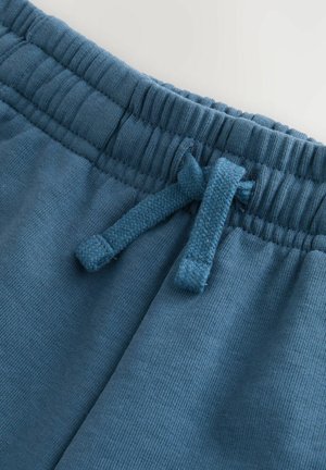Los joggers de algodón azul cuentan con una cintura elástica texturizada con un cordón integrado para ajustarlos y un acabado de tela suave.