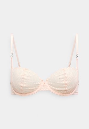 Light pink lace bra with molded cups, scalloped edges, and adjustable strap details. The fabric features a geometric pattern.