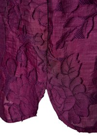 Violetti brodeerattu kangas, jossa on kukkakuvioita, tekstuuri pintastruktuurilla ja hienovaraisella kiillolla. Suunnitelmassa on lehtiä ja kolmiulotteisia yksityiskohtia.