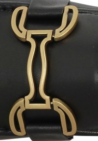 Cintura in pelle nera con una fibbia astratta in tonalità oro caratterizzata da linee morbide e curve, che mette in risalto un design moderno e elegante.