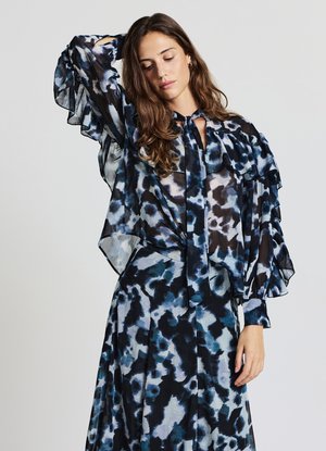 Camicia trasparente e gonna con motivo astratto blu e nero. Presenta maniche a volant, collo con fiocco e una silhouette fluida. Tessuto leggero.