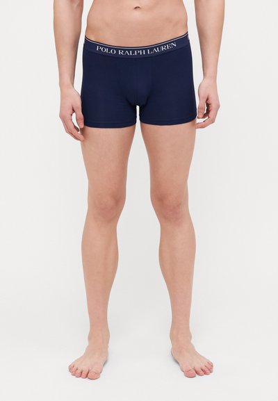 Tummansinisiä puuvillaboksereita, joissa on muotoiltu malli, joustava vyötärö, jossa on valkoiset "POLO RALPH LAUREN" -tekstit, ja sileä rakenne.