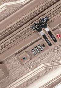 Valigia spinner in taupe metallico con superficie testurizzata, doppie cerniere, serratura TSA e combinazione per le impostazioni di sicurezza.