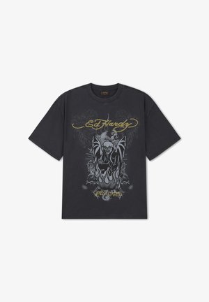 Sort Ed Hardy t-shirt med grafik af kranie og vinger, flammer og gul tekst med ordene "Ed Hardy" og "When I Cared" foran.
