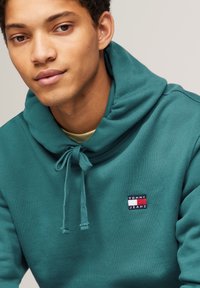 Tommy Jeans BADGE HOODIE UNISEX - Jersey con capucha - timeless teal