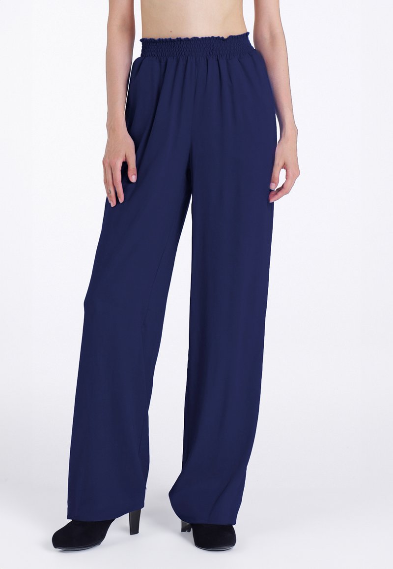 Pantaloni larghi blu navy con vita arricciata, realizzati in un tessuto leggero. Presentano due tasche laterali e una superficie liscia.
