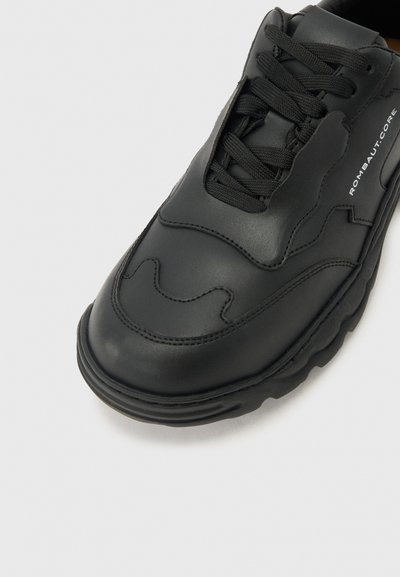 Μαύρο δερμάτινο αθλητικό παπούτσι με παχιά σόλα, μαύρα κορδόνια, καμπυλωτά ραφές στην μύτη και λογότυπο "ROMBAUT-CORE" στην πλευρική επιφάνεια.