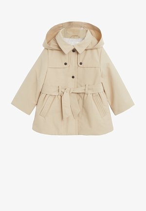 Beżowy płaszcz przeciwdeszczowy z kapturem, wykonany z gładkiego materiału, z wiązanym paskiem, zatrzaskami, dwiema przednimi kieszeniami oraz w kratkę podszewką.