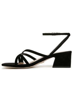 Sandales à talons en daim noir avec un talon bloc effilé, plusieurs lanières croisées et une sangle de cheville réglable pour un ajustement sécurisé.