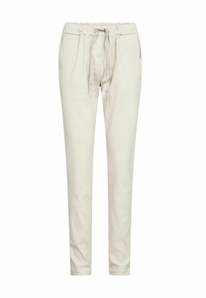 Beežid vabaaja püksid elastse vöökohaga, nöörlindiga ja küljetaskutega, kitseneva säärekujundusega valgel taustal.