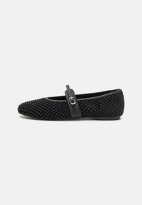 Black ballet flats with a textured mesh upper, featuring a thin black strap with a decorative silver buckle across the instep. Soft sole.