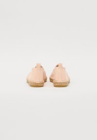 Espadrile roz deschis cu superior din pânză, talpă din jute împletit și design slip-on. Prezintă un toc scurt și un tab de tragere la spate.