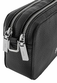 Czarna skórzana prostokątna torba z podwójnymi srebrnymi zamkami błyskawicznymi i polerowanym okuciem. Teksturowana powierzchnia z widocznymi szwami i szczegółem logo.