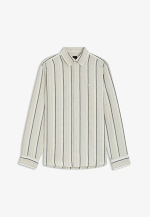 Chemise à manches longues boutonnée avec des rayures verticales beige, blanches et foncées, dotée d'un col boutonné et d'un logo discret sur la poitrine.