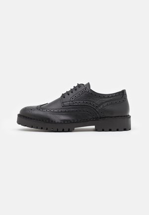 Sort læder oxford-sko med brogue-detaljer, snørebåndsdesign, rund tå og holdbar gummisål med struktureret mønster for bedre greb.