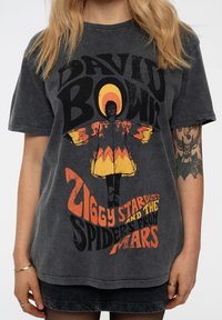 Gray cotton t-shirt featuring a large graphic of David Bowie's Ziggy Stardust, with orange and yellow accents and bold text.