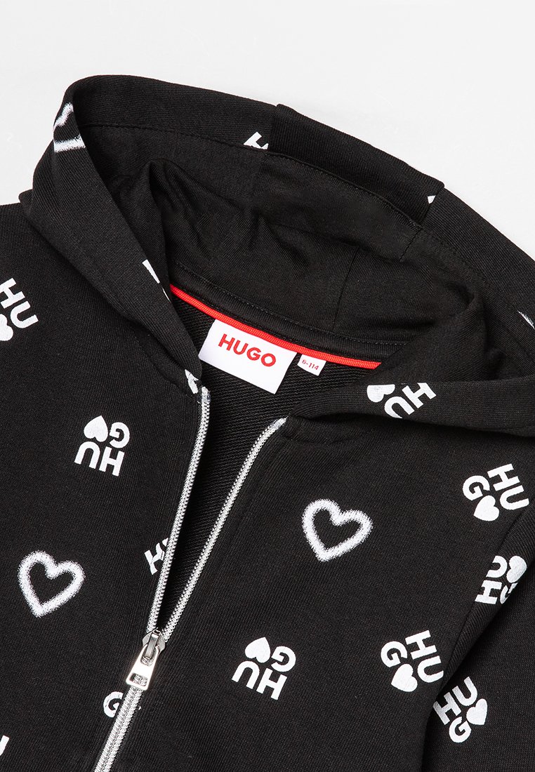 Czarna bluza z kapturem na zamek, wykonana z bawełny, z białymi nadrukowanymi napisami i wzorami serc. Wewnątrz znajduje się czerwona metka z napisem "HUGO."