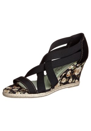 Kilesandal med sorte krydsede elastiske stropper og blomstermønstret hæl og fodseng, med en sålkant med vævet tekstur.