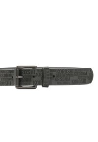 Cinturón de goma gris con marca en relieve, presenta una hebilla metálica y un lazo a juego, diseñado con patrones de texto repetidos.