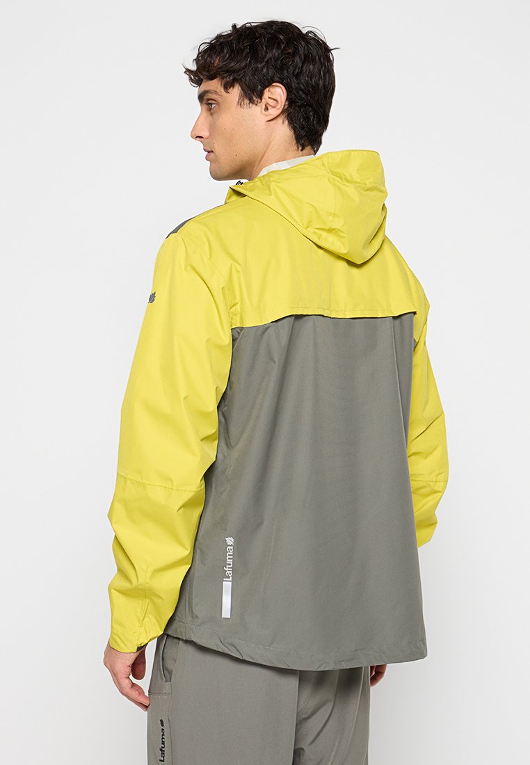 Veste pour homme avec une capuche et une partie supérieure jaune vif, et un bas de corps gris ; fabriquée en matériau léger et résistant à l'eau.