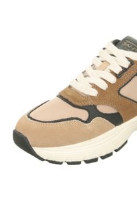 Sneaker aus einer Kombination von beigem Wildleder und Mesh, schwarzen Akzenten, cremefarbenen Schnürsenkeln und einer strukturierten Gummisohle mit leichtem Absatz.