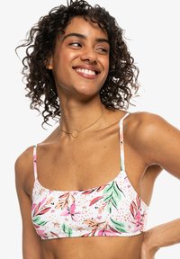 Floral bikini top i hvid med pink og grønne bladmønstre, understøttet af tynde justerbare stropper og en firkantet udskæring. Glat stofstruktur.