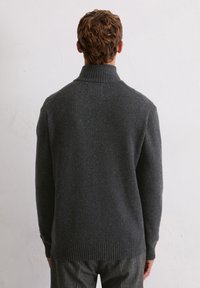 Sweter w kolorze węgla drzewnego, dziany, z wysokim kołnierzem, ściągaczami przy rękawach i u dołu, z teksturowanym wzorem. Widok od tyłu.