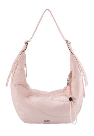 Soft pink crescent-shaped shoulder bag with adjustable straps, zipper pocket, elastic cord, and "Studio Berlin" logo on front bottom.
