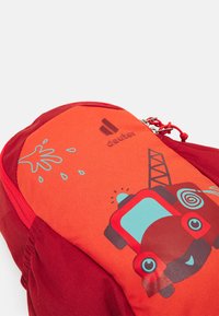 Red backpack featuring a textured orange panel with a cartoon fire truck design, blue accents, and a playful water splash graphic.