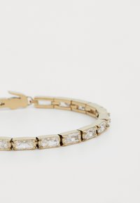 Gold-tone bracelet featuring rectangular clear crystals, linked with flat segments. Smooth finish with a lobster clasp closure.