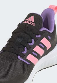 Scarpa sportiva nera con tomaia in rete, dettagli rosa e viola, e suola bianca. Presenta lacci e un collare imbottito per il comfort.