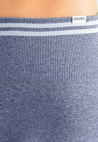 Blauer gerippter Sportbund mit glatter Textur und hellfarbigen Streifenakzenten. Verfügt über ein kleines Markenlabel oben.