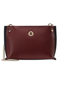 Bolso de cuero burdeos con acentos negros, un emblema dorado en la parte frontal, cadena para el hombro y textura suave.