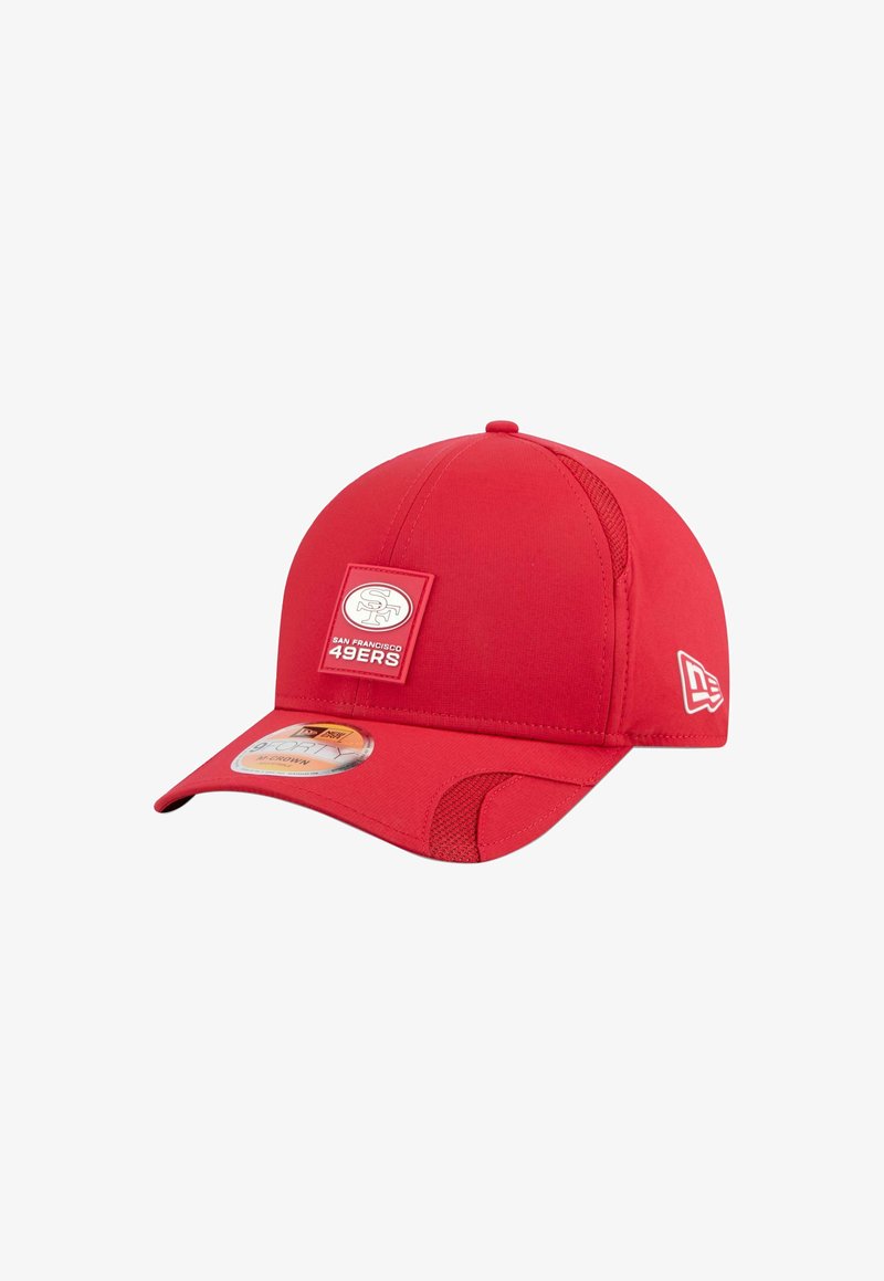 Casquette de base-ball rouge en tissu avec une texture lisse. Présente un patch carré du logo des San Francisco 49ers à l'avant et des détails en filet sur les côtés.
