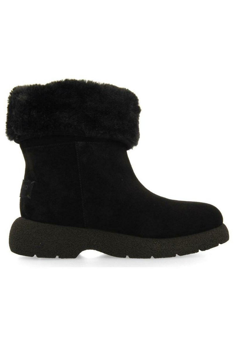 Botines de ante negro con un puño de piel sintética, punta redondeada, suela de goma negra texturizada, con un pequeño parche de logo en el lateral.