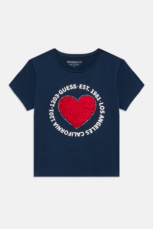Temno modra majica s kratkimi rokavi z rdečim teksturiranim srcem spredaj, obdanim z belim napisom »GUESS EST. 1981 LOS ANGELES CALIFORNIA.«