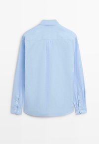 Světle modrá košile s dlouhým rukávem, standardním límcem, zadním skladem, manžetami na knoflíky a hladkou texturou. Navržena pro uvolněný střih.