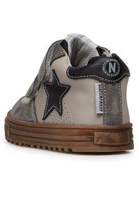 Sneaker impermeabile con tomaia in pelle grigia chiara, dettagli in suede grigio, un design a stella nera e suola in gomma marrone.