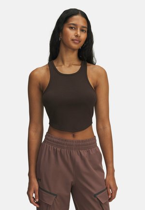 Haut court marron à côtes avec un col rond et des coutures minimales, associé à un pantalon marron clair avec des poches latérales et une taille élastique.