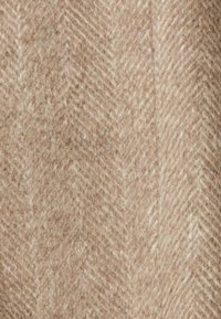 Tkanina w wzór pepitki w jasnobeżowych tonach, o miękkiej, pluszowej fakturze, ukazująca wyraźne, ukośne linie i włókna.