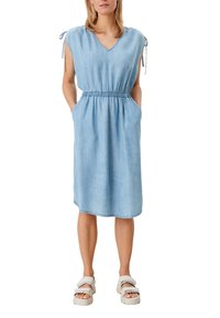 Ljusblå chambrayklänning med V-ringning, korta ärmar med knyt, elastisk midja och sidofickor, som når till halva vaden.