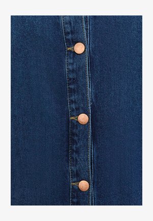 Gonna in denim con cinque bottoni bronzati sul davanti. Tessuto blu scuro con cuciture evidenti e una texture liscia.