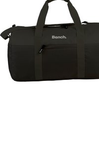 Duffeltas in donkergroen, gemaakt van stof met hexagonale patronen, voorzien van stevige handvatten en een zilveren logo. Ritsvak inbegrepen.