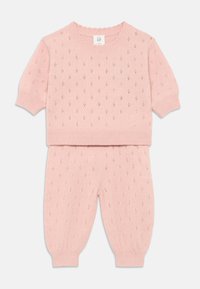 Conjunto de dos piezas de punto rosa que incluye un top de manga corta y pantalones ajustados. El diseño presenta patrones de diamante y puños, dobladillo y escote acanalados.