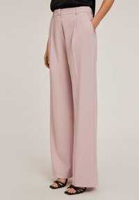 Roze wijd uitgesneden broek met een op maat gemaakte pasvorm, voorzien van zijzakken en een gladde textuur, gecombineerd met zwarte sandaaltjes met bandjes.