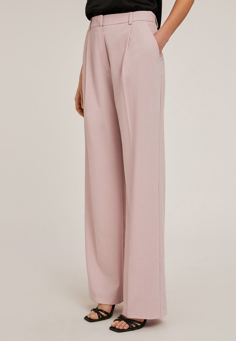 Roze wijd uitgesneden broek met een op maat gemaakte pasvorm, voorzien van zijzakken en een gladde textuur, gecombineerd met zwarte sandaaltjes met bandjes.