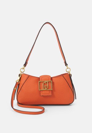 Pomarańczowa torebka ze skóry o fakturze, z detalem w postaci złotej klamry, pojedynczym paskiem i odpinanym paskiem na nadgarstek na białym tle.